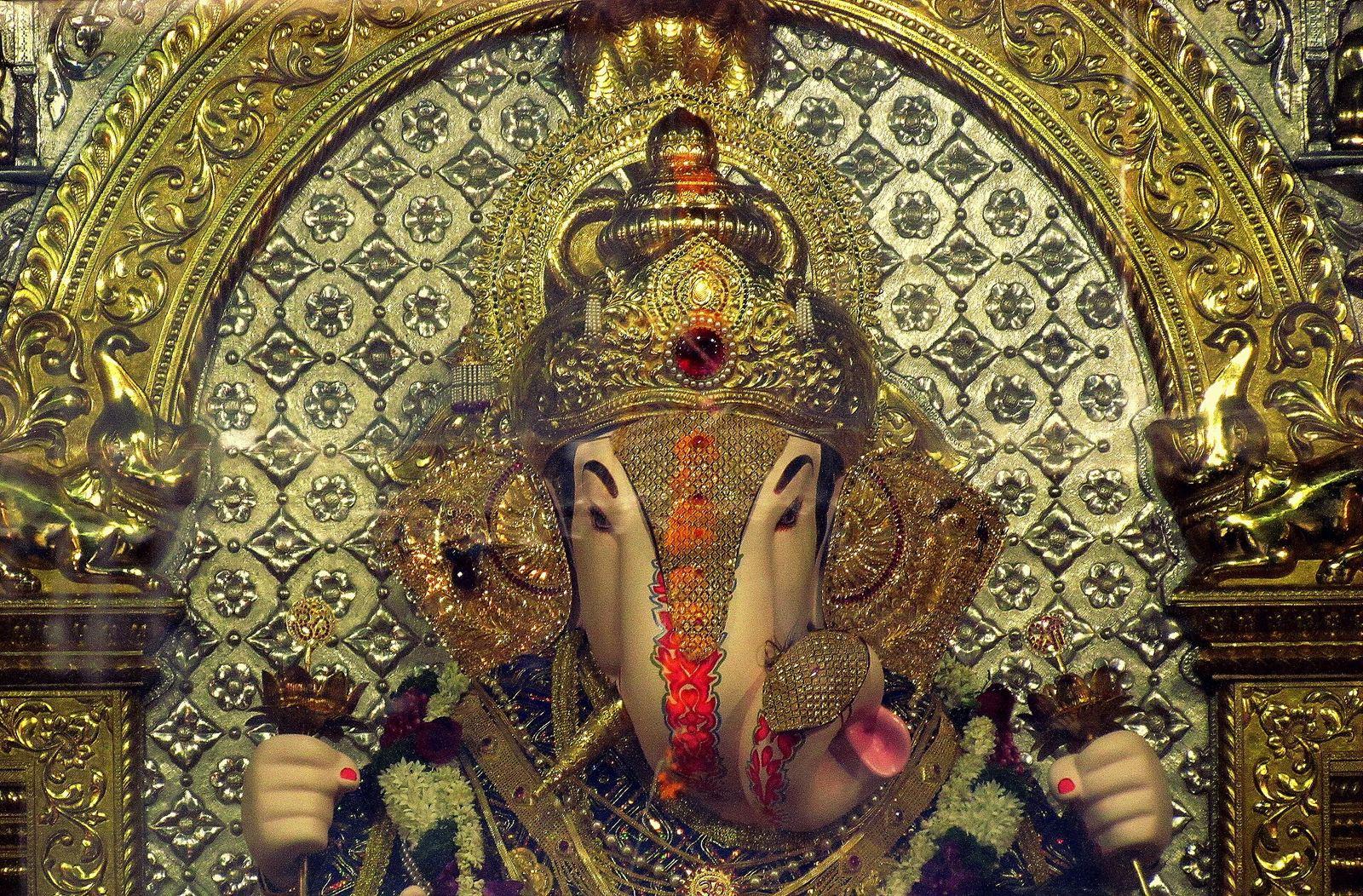 Seated idol of Shrimant Dagdusheth Halwai Ganpati in the sanctum at Budhwar Peth, Pune, with a gold crown and ornaments