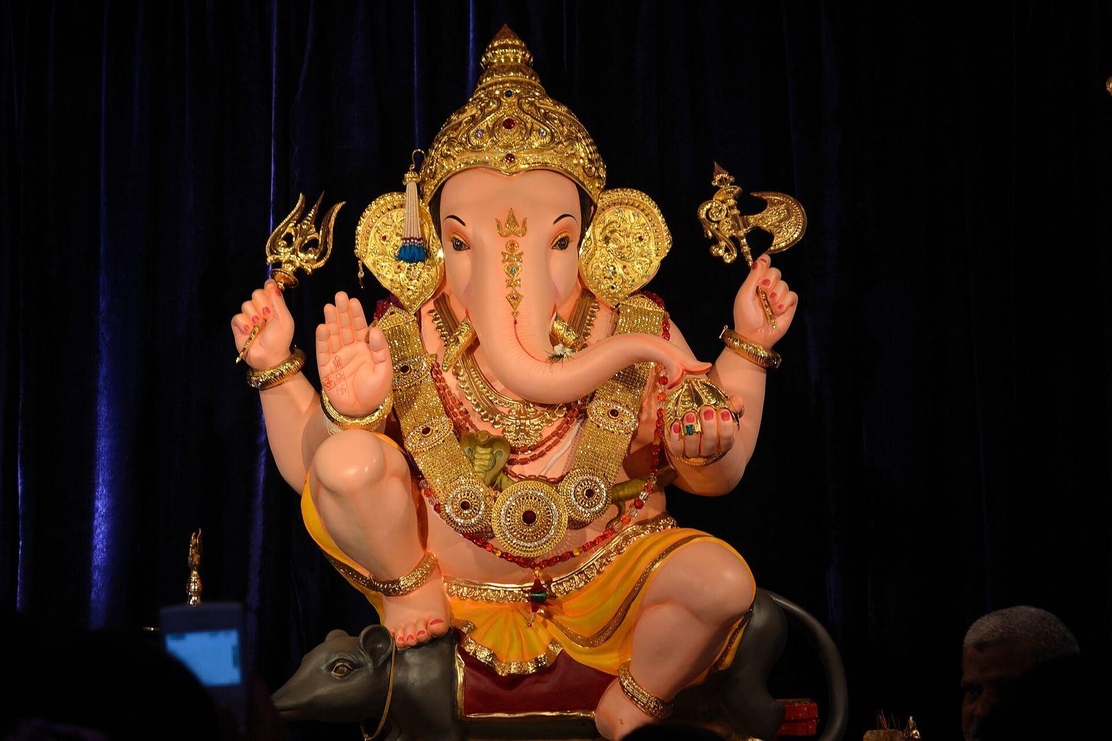 Festival idol of Guruji Talim Ganpati, seated with a crown and a mouse at its feet